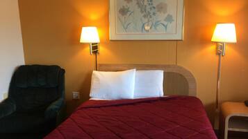 Una habitación de hotel con una cama, dos lámparas de pared, una silla y un cuadro.