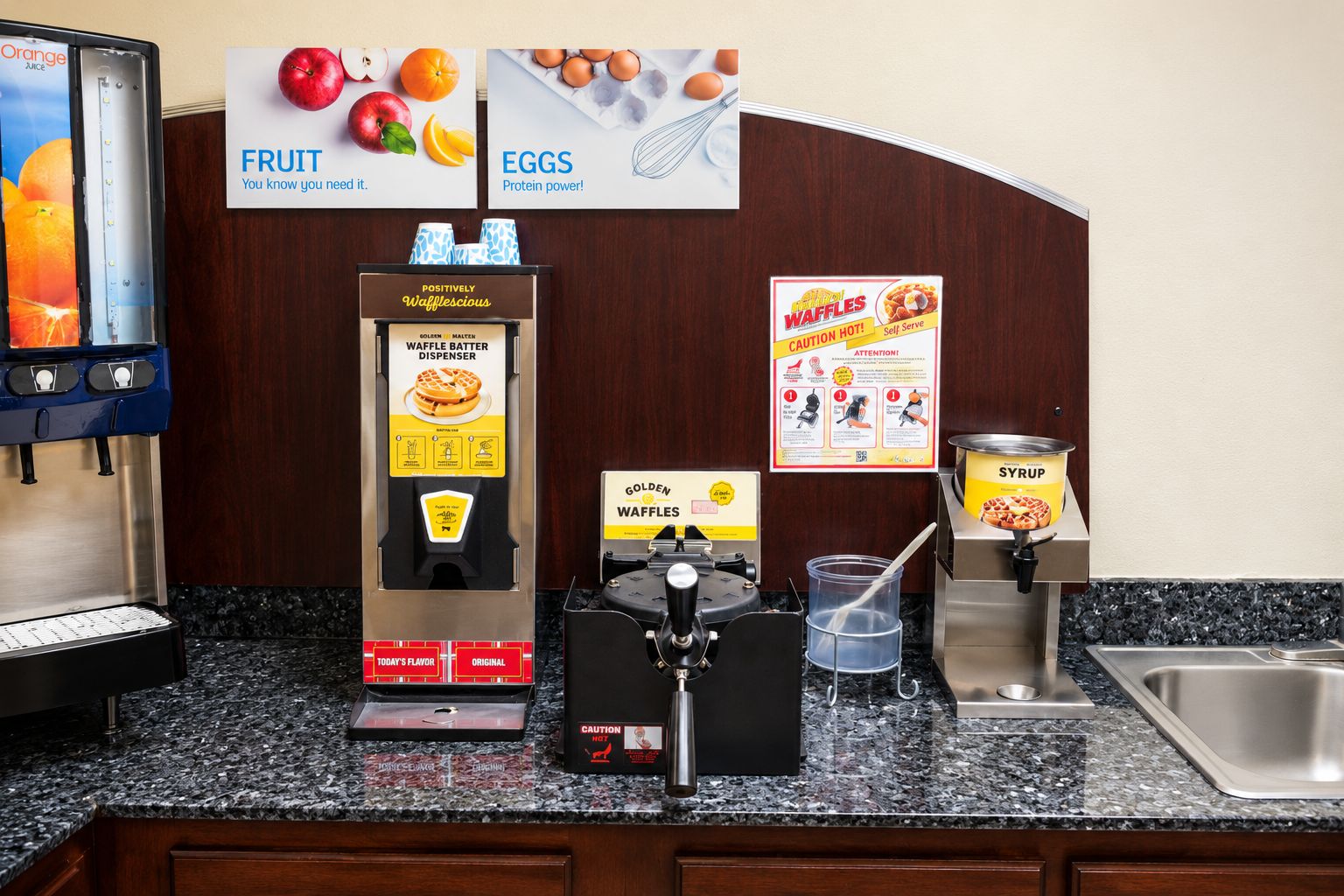 Ein Selbstbedienungsbereich mit Waffelautomat, Sirup und Waffeleisen.