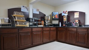 Un bar à petit-déjeuner équipé d’une machine à café, d’un distributeur de céréales et d’un distributeur de boissons aux fruits.