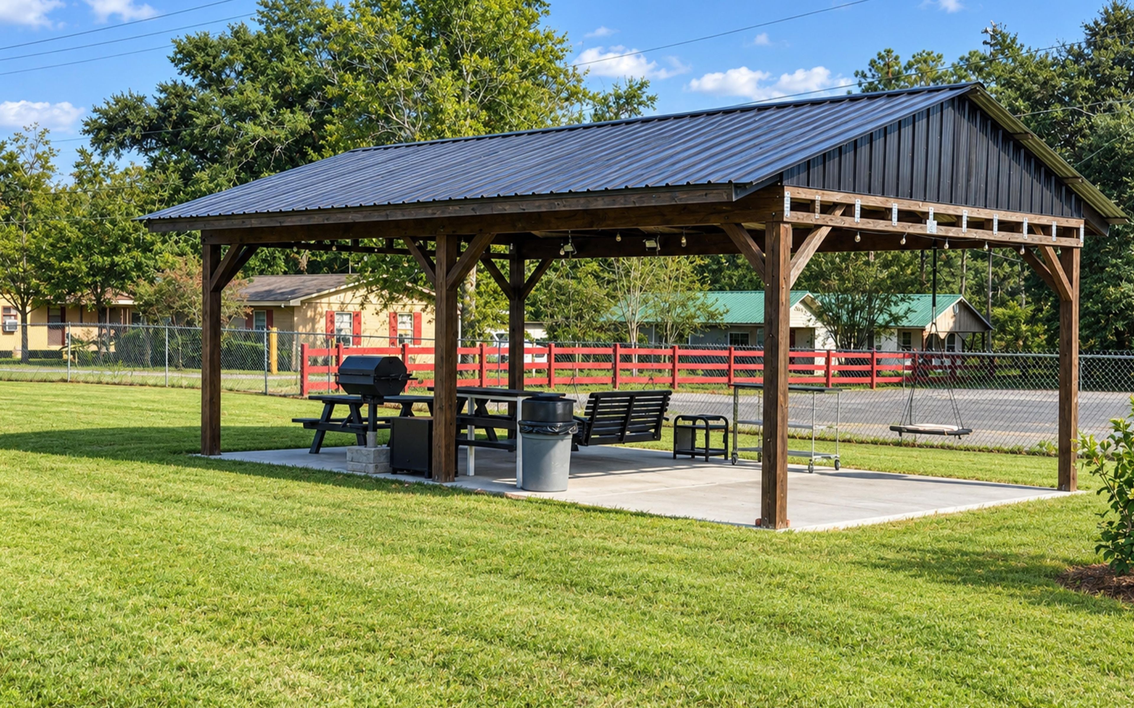 A covered picnic area with benches and a barbecue grill.