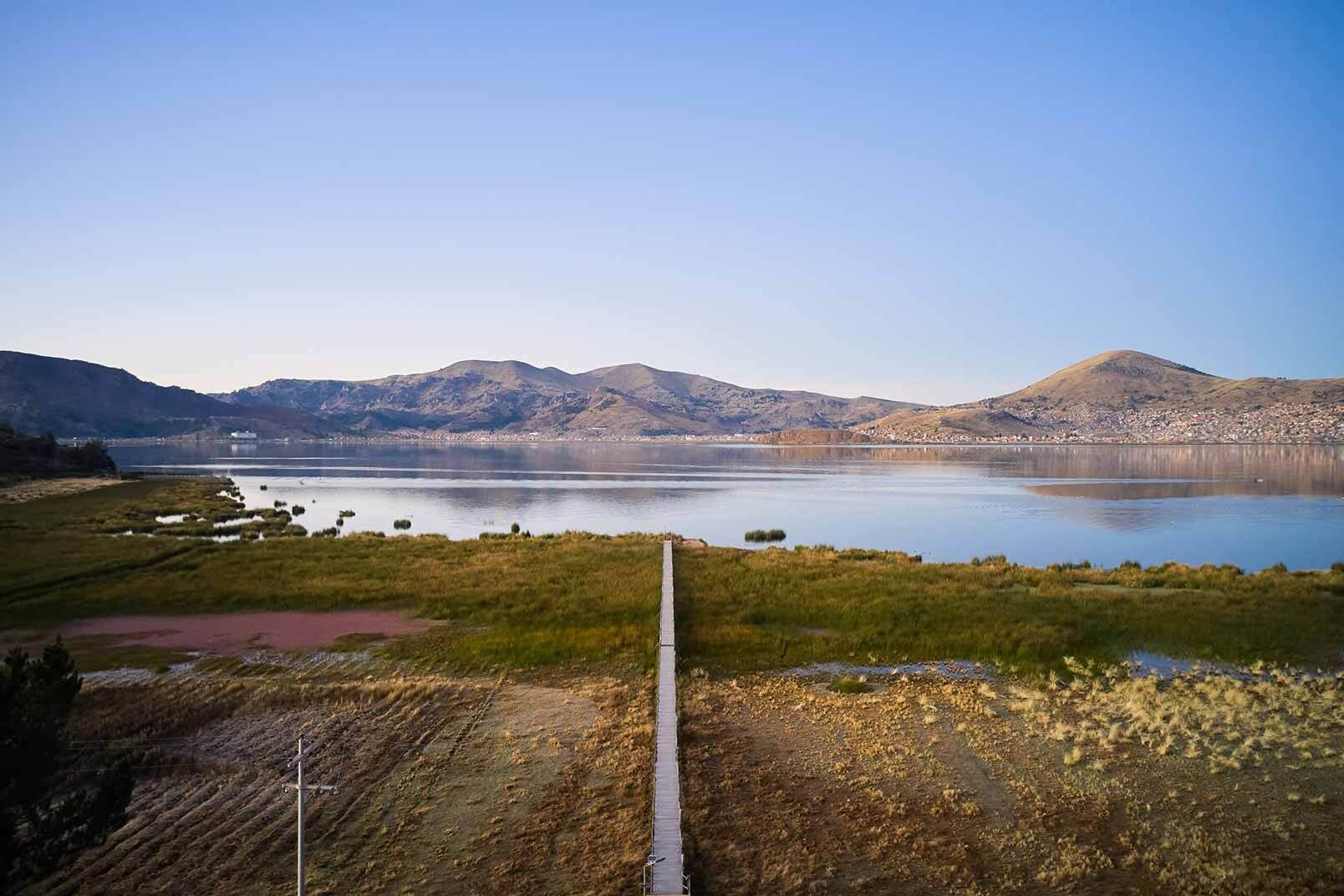 A view of a lake with mountains in the background and a clear sky.