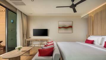 A modern hotel room with a bed, a desk, a chair, a TV, and a ceiling fan.