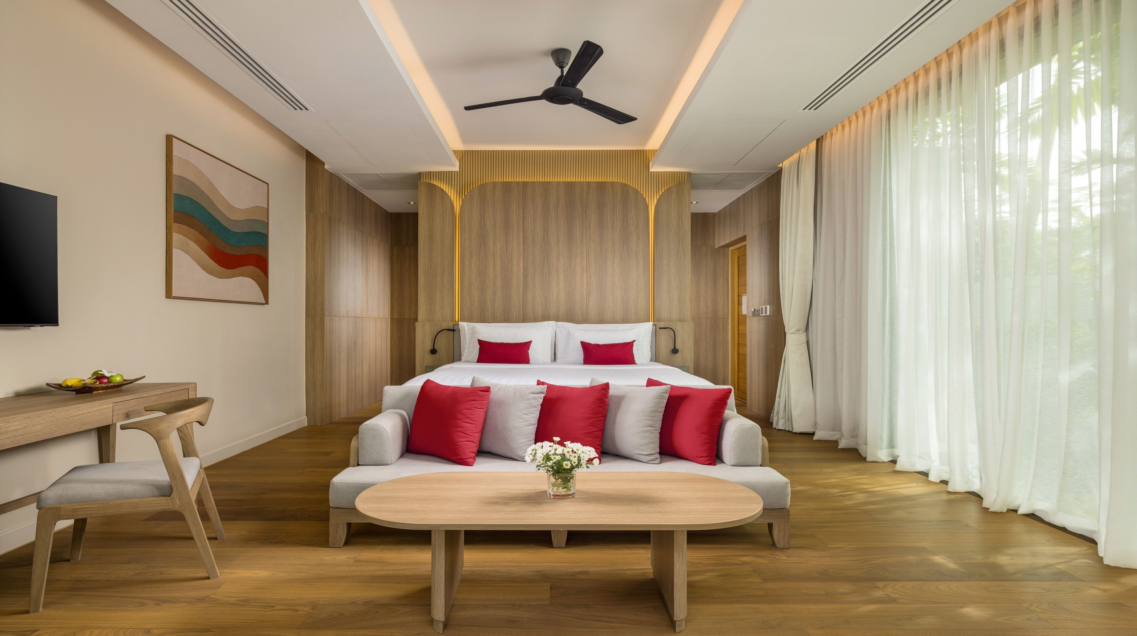 Une chambre d’hôtel moderne, dotée d’un grand lit, d’un bureau et d’une télévision.