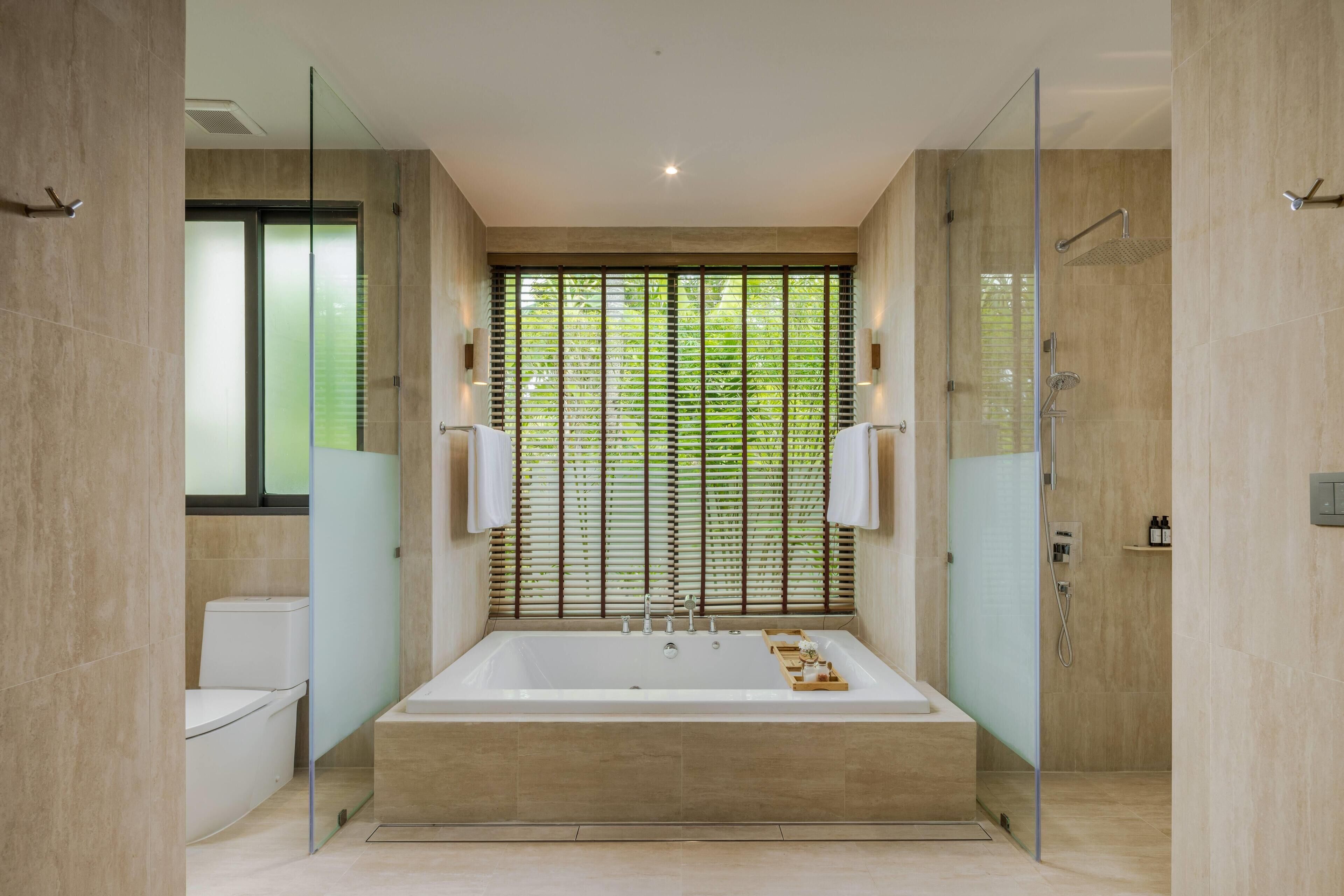 Un baño moderno con una bañera grande, un inodoro y una zona de ducha.