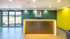 Un comptoir d’accueil d’hôtel avec une enseigne indiquant : « Qualité garantie par Choice Hotels ».