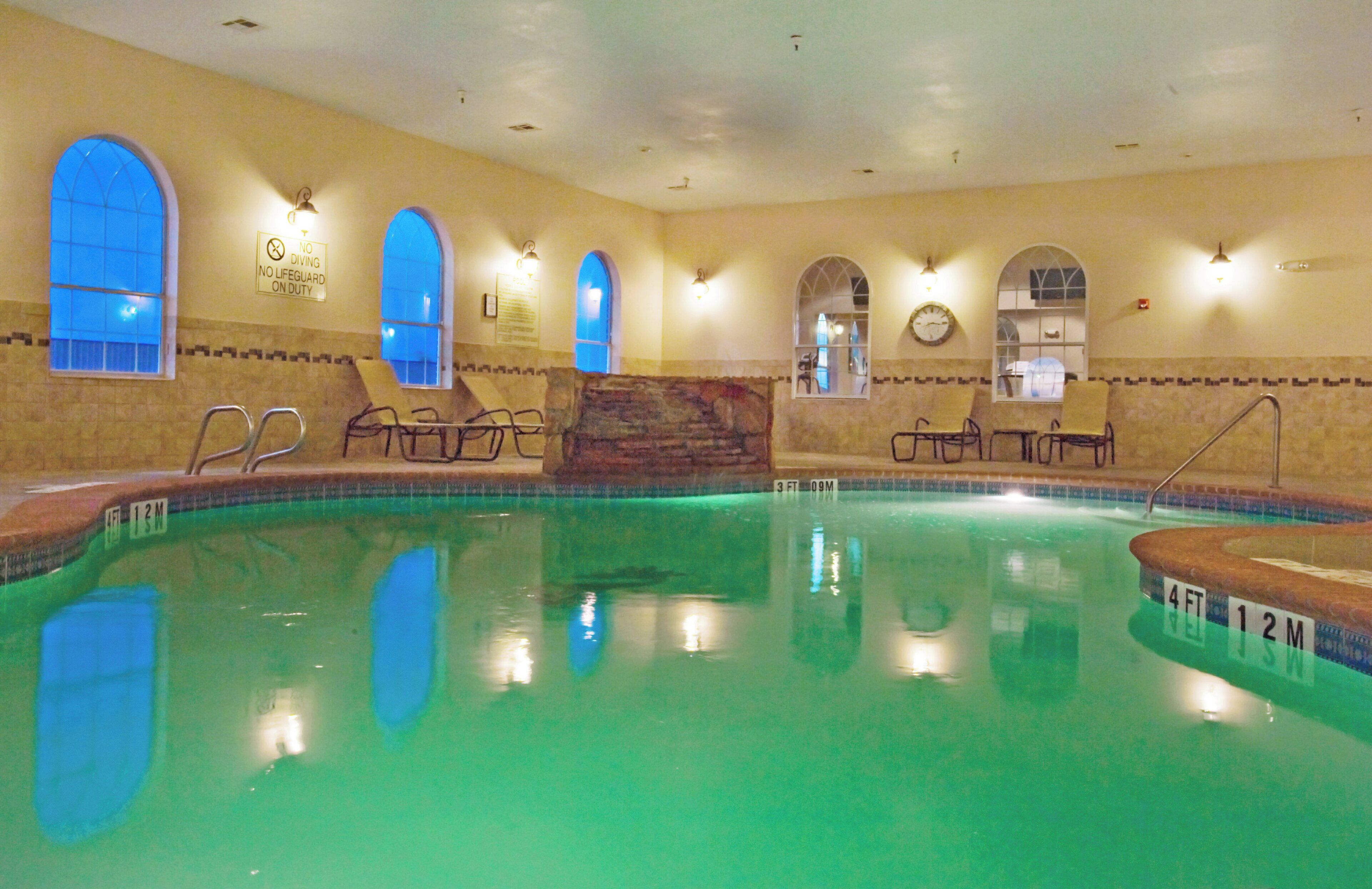 Una piscina interior amb aigua cristal·lina, diverses plataformes de llançament i gandules.