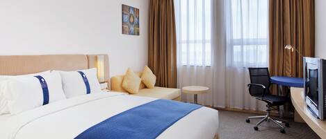 Une chambre d’hôtel avec un grand lit, un bureau, une chaise et un téléviseur.