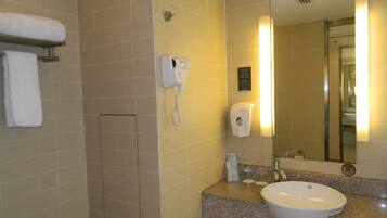 Baño con lavamanos, espejo, toallero y secamanos.