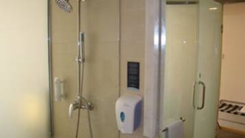 Ein Badezimmer mit Glasdusche, Handtuchhalter und sichtbarer Toilette.