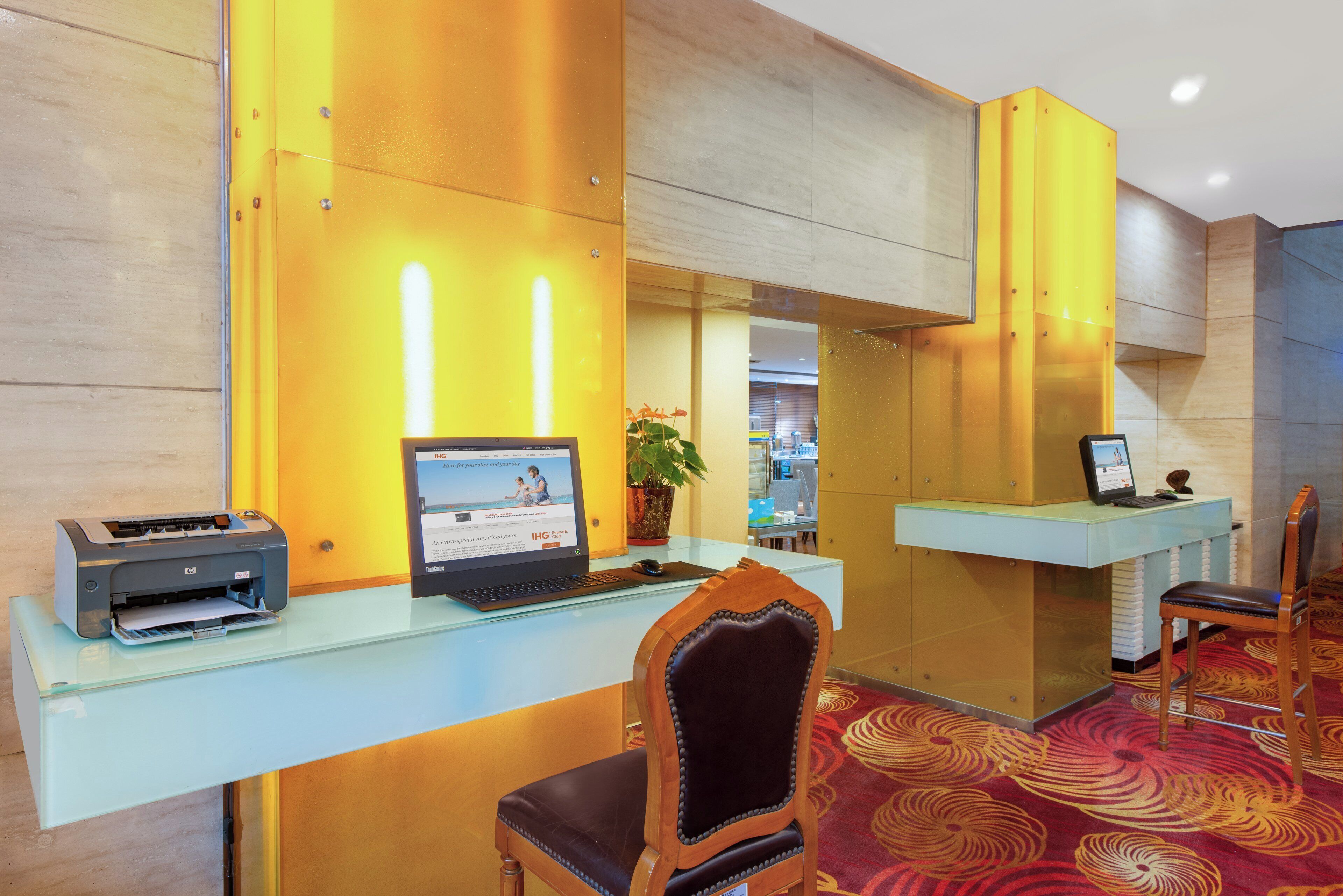 A reception desk with a computer, a printer, and a chair.