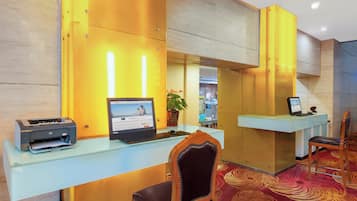 A reception desk with a computer, a printer, and a chair.