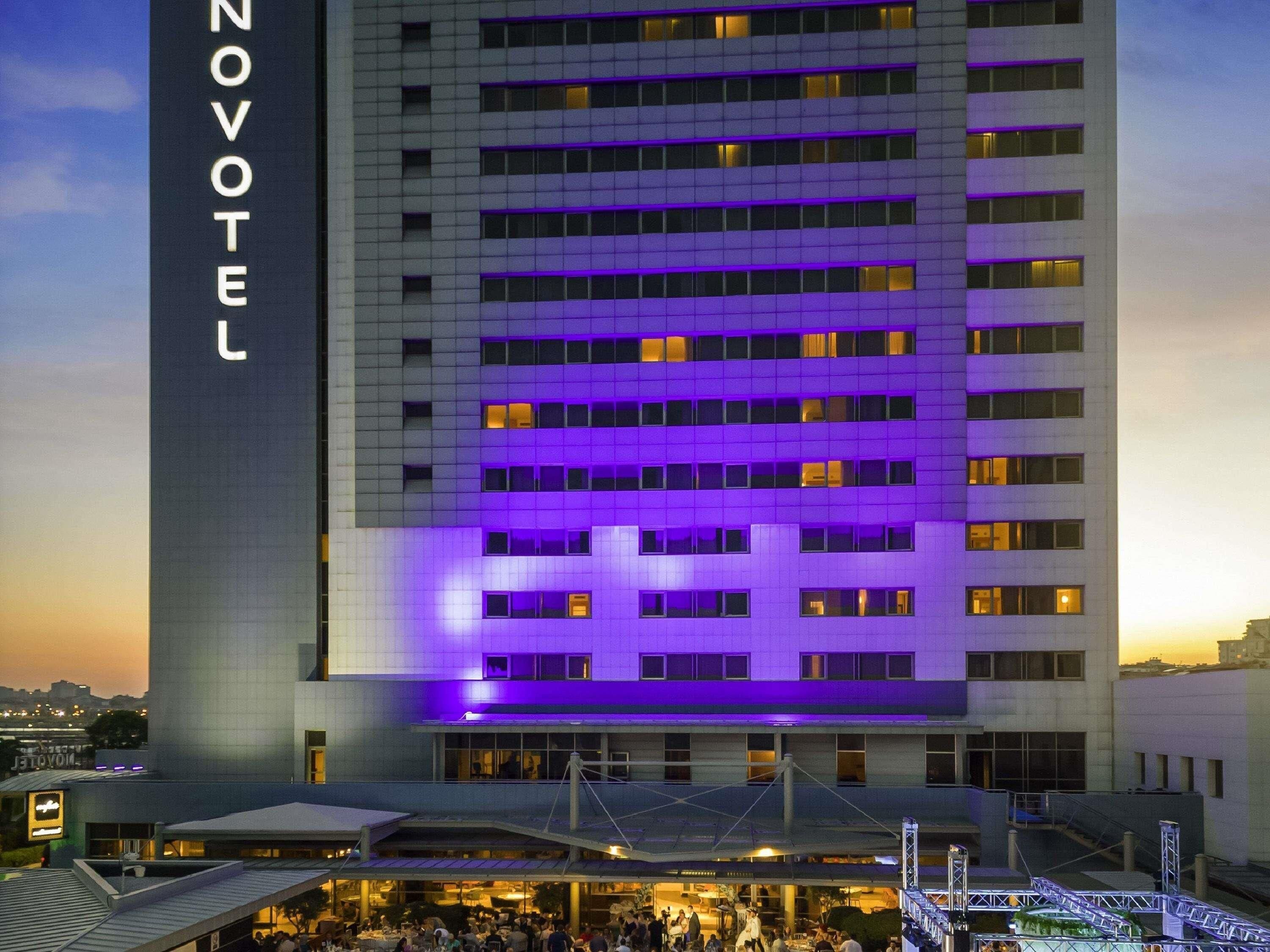 Ein Hotel mit modernem Design, mit einem gut sichtbaren 'NOVOTEL'-Schild an der Seite.