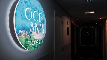 Un letrero circular con el texto "OCEAN'S FLOOR 2" en una pared de un pasillo.