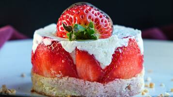 A dessert with strawberries and cream on a plate.