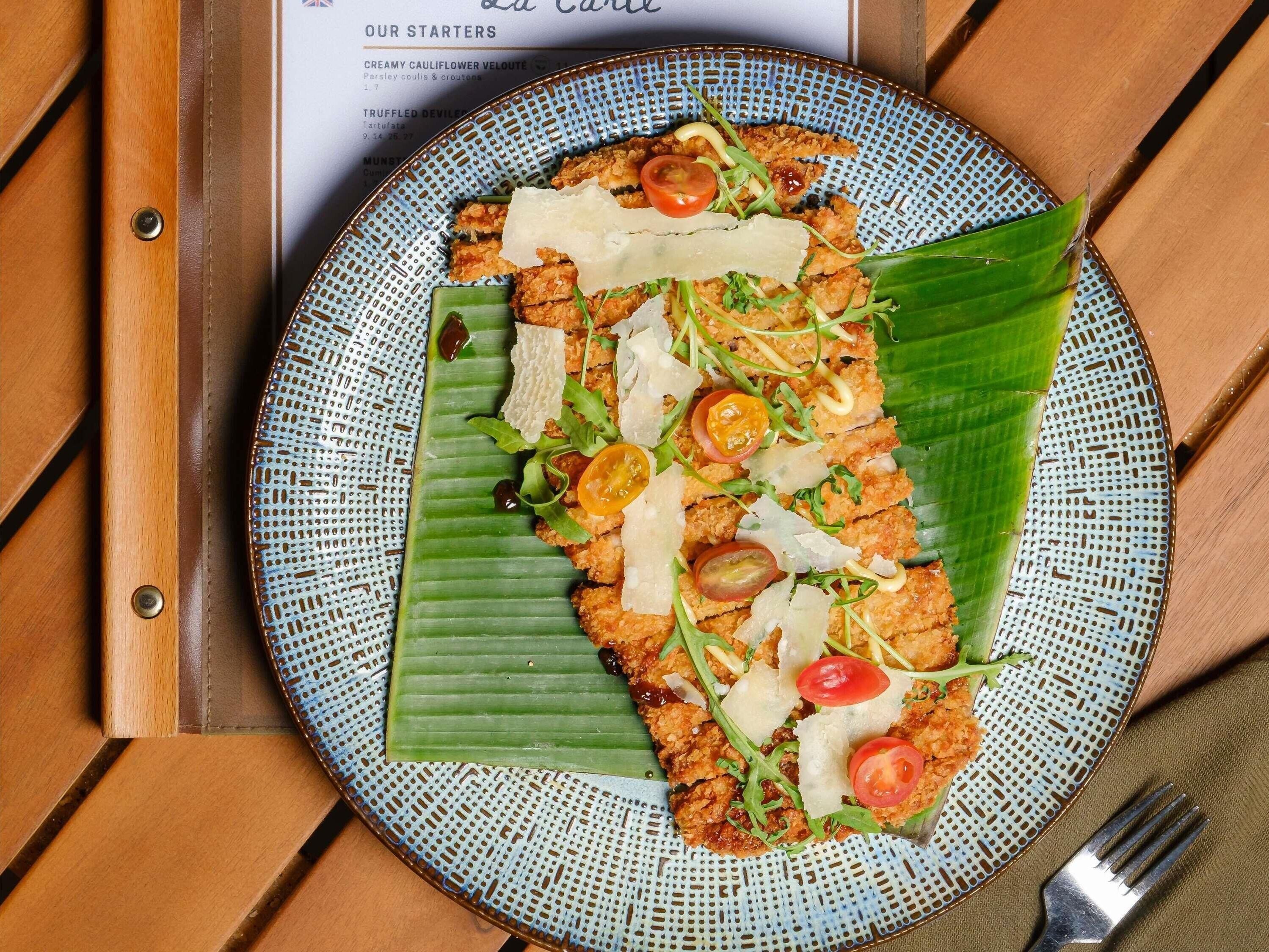 A plate of food on a table with a menu in the background.
