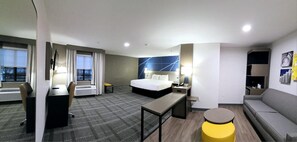 A hotel room with a bed, desk, chair, and a small table. - Comfort Inn & Suites Savannah Airport (Savannah)