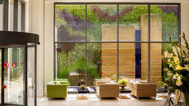 A spacious lobby with large windows, a reception desk, and comfortable seating areas.
