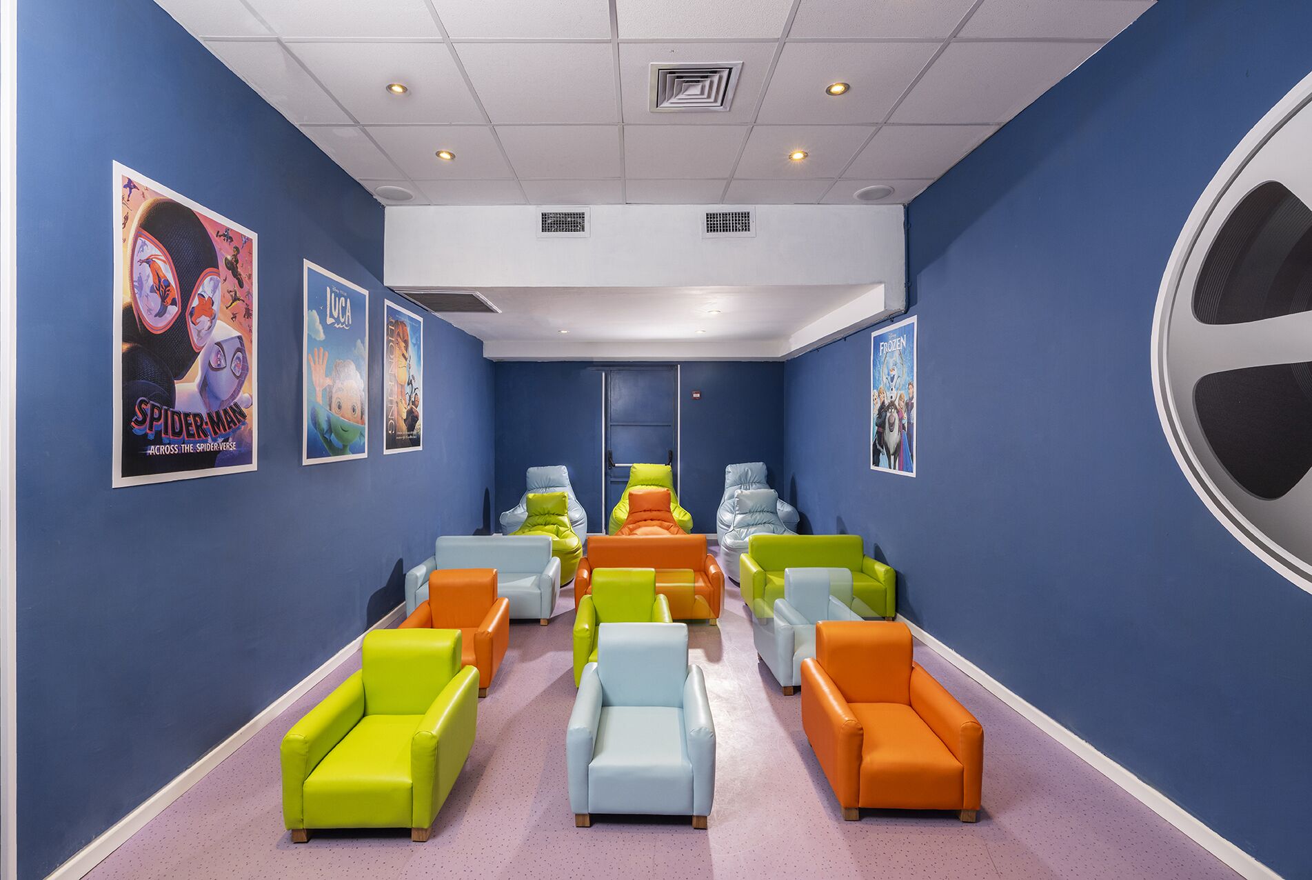 A room with blue walls, colorful chairs, and movie posters.