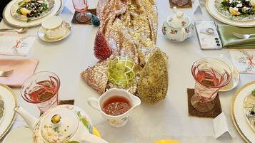 Una mesa dispuesta para una comida con varios platos, teteras y elementos decorativos.
