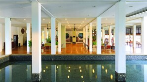 A spacious lobby with a central pool, multiple seating areas, and a modern architectural design. - The Blue Water - Geoffrey Bawa Heritage Resort Hotel (Wadduwa)