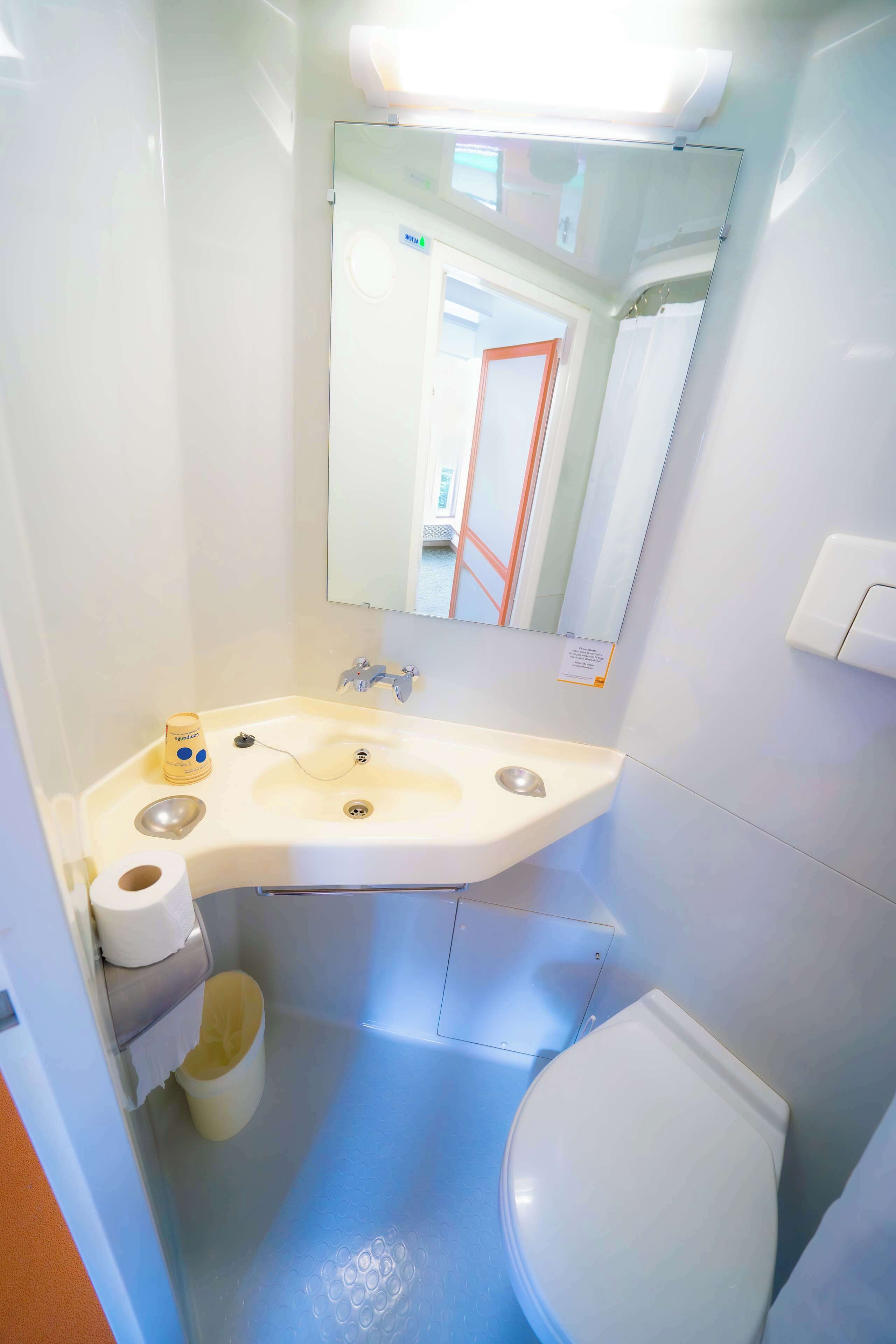 Une petite salle de bain avec un lavabo, des toilettes et un miroir.