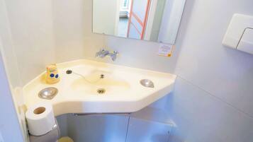 Une petite salle de bain avec un lavabo, des toilettes et un miroir.