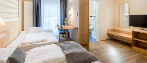 Driepersoonskamer | Luxe beddengoed, een kluis op de kamer, een bureau, geluiddichte muren