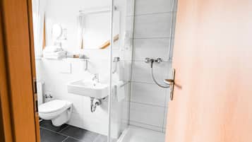 Un baño moderno con inodoro, lavabo y ducha.
