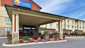 A Comfort Inn & Suites hotel with a covered entrance, multiple floors, and landscaped gardens. - Comfort Inn & Suites adj to Akwesasne Mohawk Casino (Hogansburg)