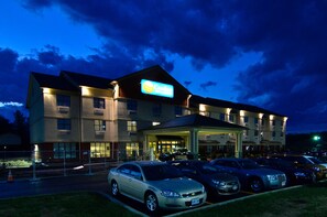 A hotel with a large sign, multiple parking spaces, and a well-lit entrance. - Comfort Inn & Suites adj to Akwesasne Mohawk Casino (Hogansburg)
