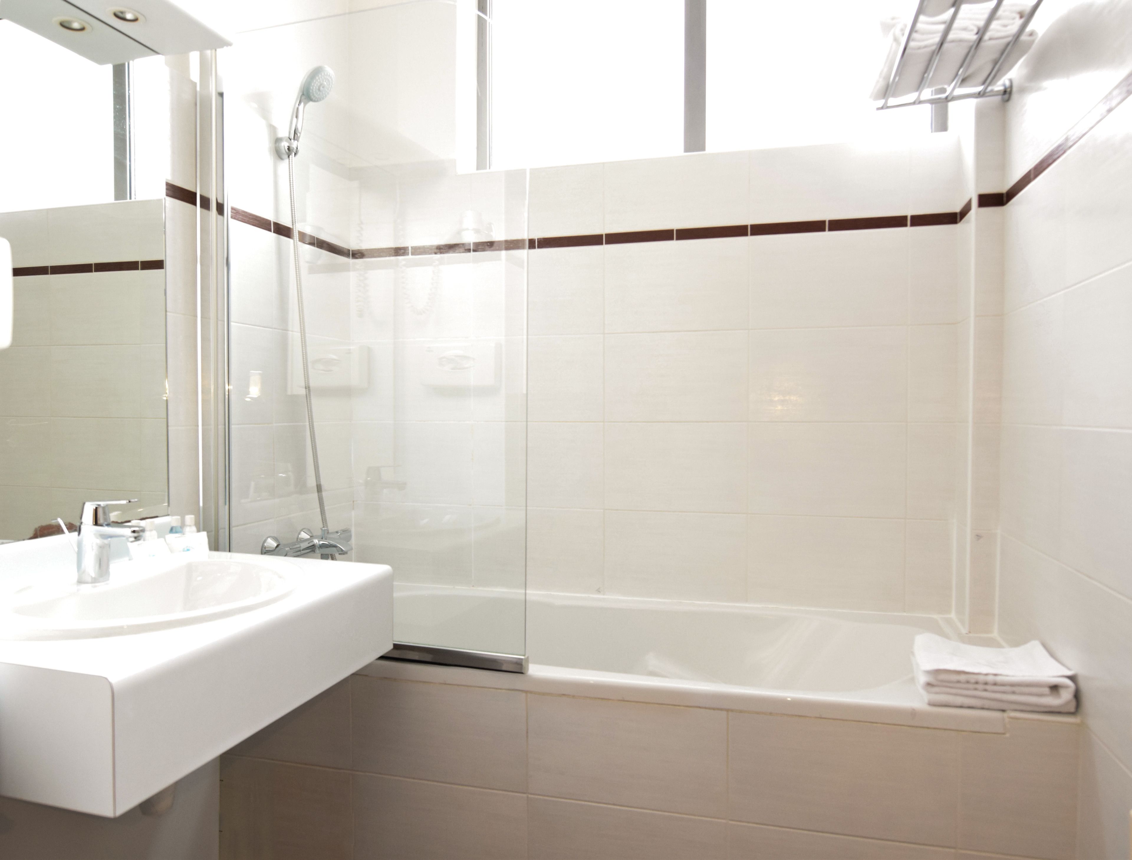 A modern bathroom with a glass-enclosed shower, a white sink, and a bathtub.