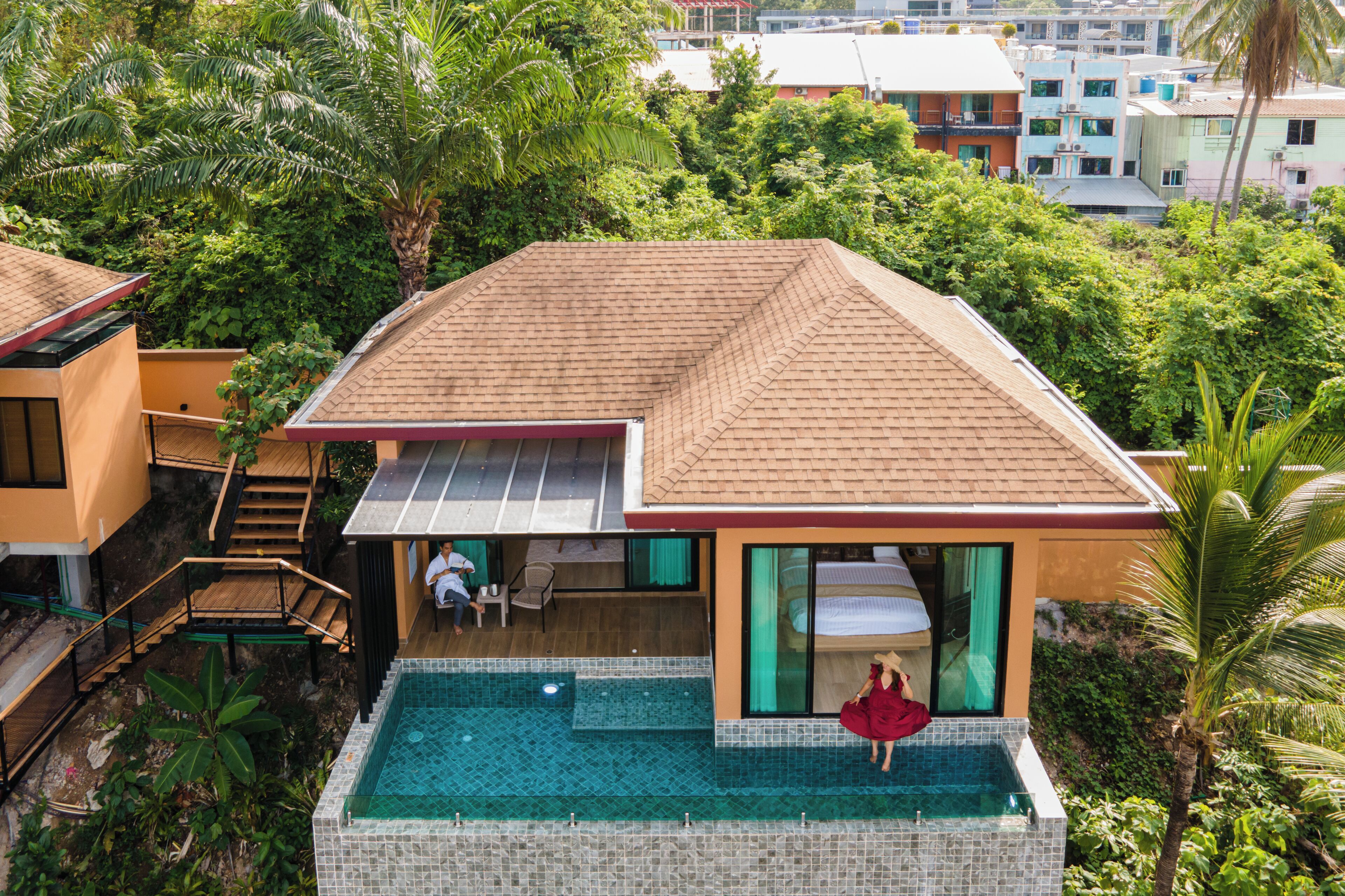 Une villa moderne dotée d’une piscine, d’un patio couvert et offrant une vue sur la verdure environnante.