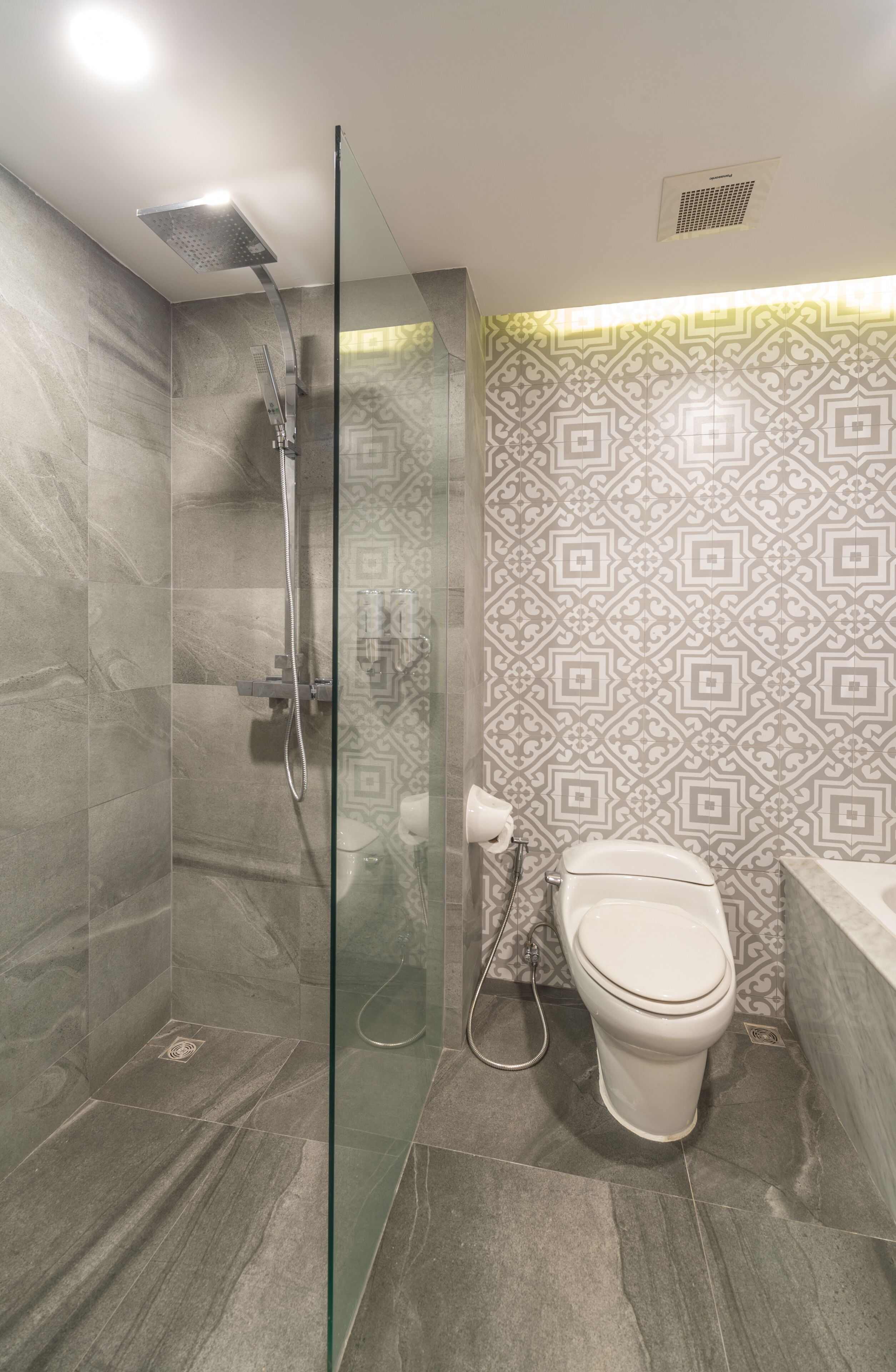 A modern bathroom with a glass-enclosed shower, a toilet, and a bathtub.