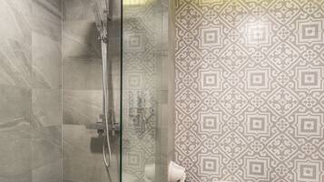 A modern bathroom with a glass-enclosed shower, a toilet, and a bathtub.