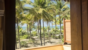 A view of a beach with palm trees and the ocean. - Txai Resort Itacaré (Itacaré)