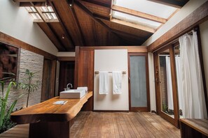 A modern bathroom with a wooden vanity, a large mirror, and a skylight. - Txai Resort Itacaré (Itacaré)