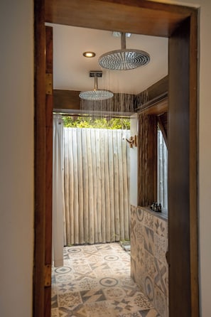 A shower area with a rain showerhead, a wooden fence, and patterned floor tiles. - Txai Resort Itacaré (Itacaré)