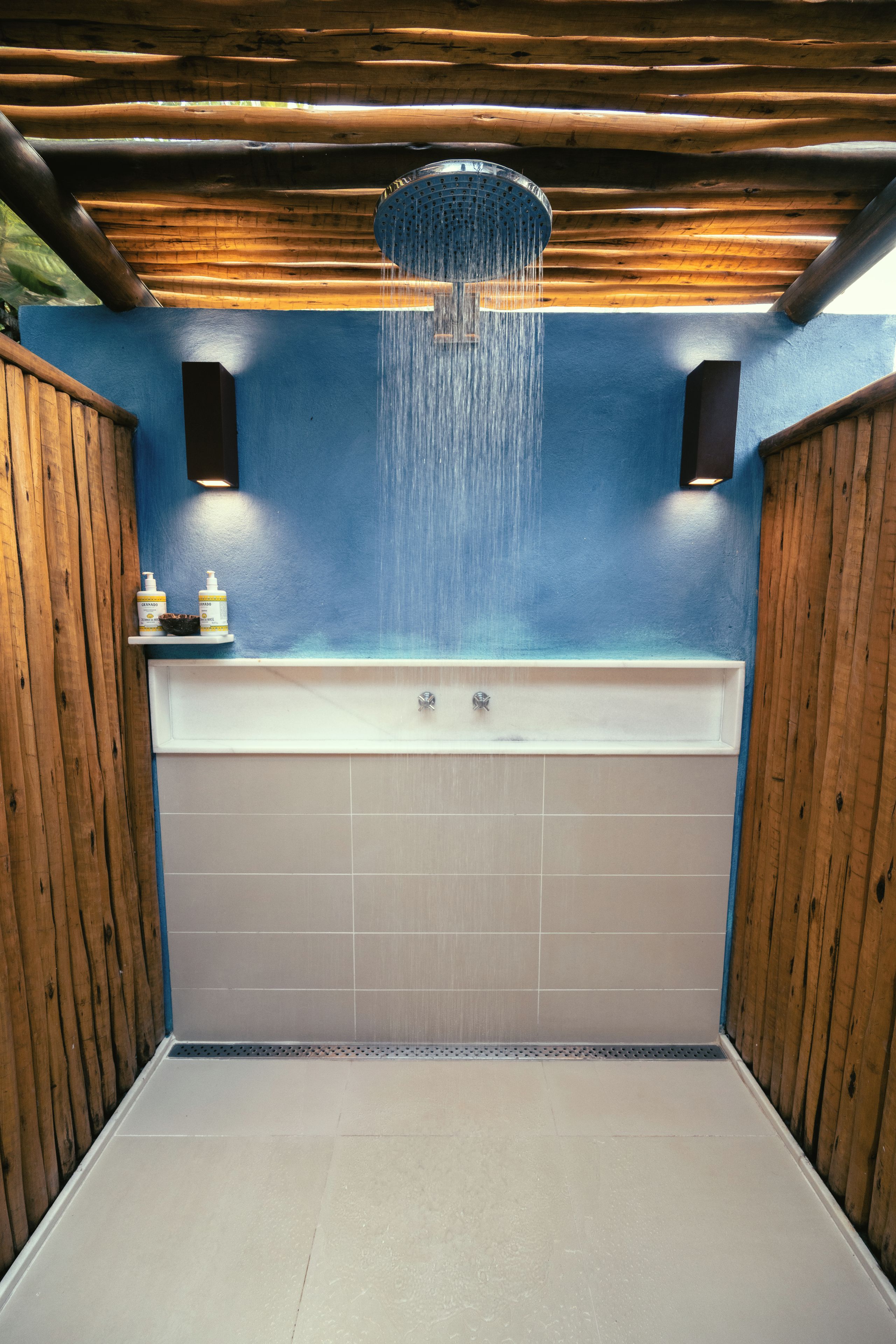 Une salle de bain avec une baignoire, des murs en bois et un plafond bleu.