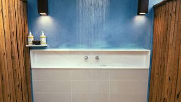Une salle de bain avec une baignoire, des murs en bois et un plafond bleu.