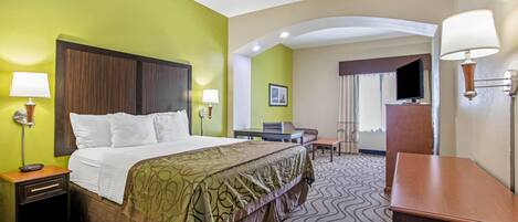 A hotel room with a bed, nightstands, a desk, a chair, and a TV.