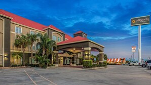 A hotel with a red roof, palm trees, and a sign reading "La Quinta". - La Quinta Inn & Suites by Wyndham Corpus Christi Airport (Corpus Christi)