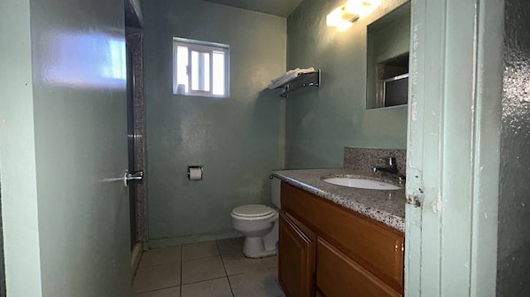 Un bagno con il water, un lavandino e una finestra.
