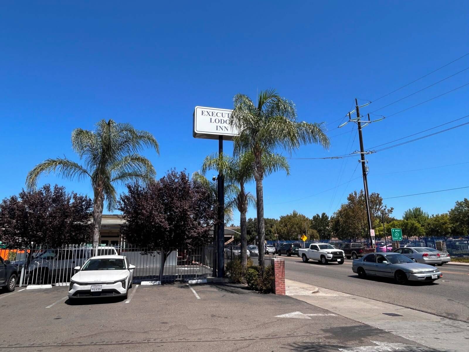 A parking lot with a sign for the EXECUTIVE LODGE INN.