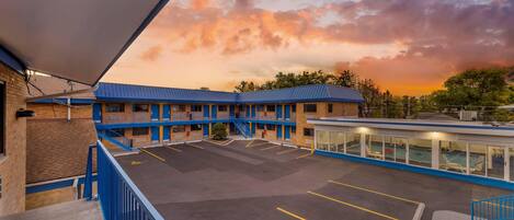 Un motel à la façade bleue et blanche, doté d’un parking et d’un espace piscine.