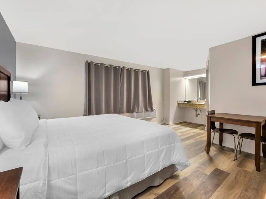 Ein Hotelzimmer mit Bett, Schreibtisch und Stuhl.