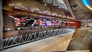 A modern hotel lobby with a large digital screen displaying vibrant visuals, a marble reception desk, and a spacious tiled floor. - Hard Rock Hotel and Casino Tulsa (Catoosa)
