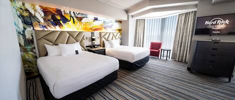 Une chambre d’hôtel avec un grand lit, un lit plus petit, un bureau, une télévision et une vue sur l’hôtel et le casino Hard Rock.