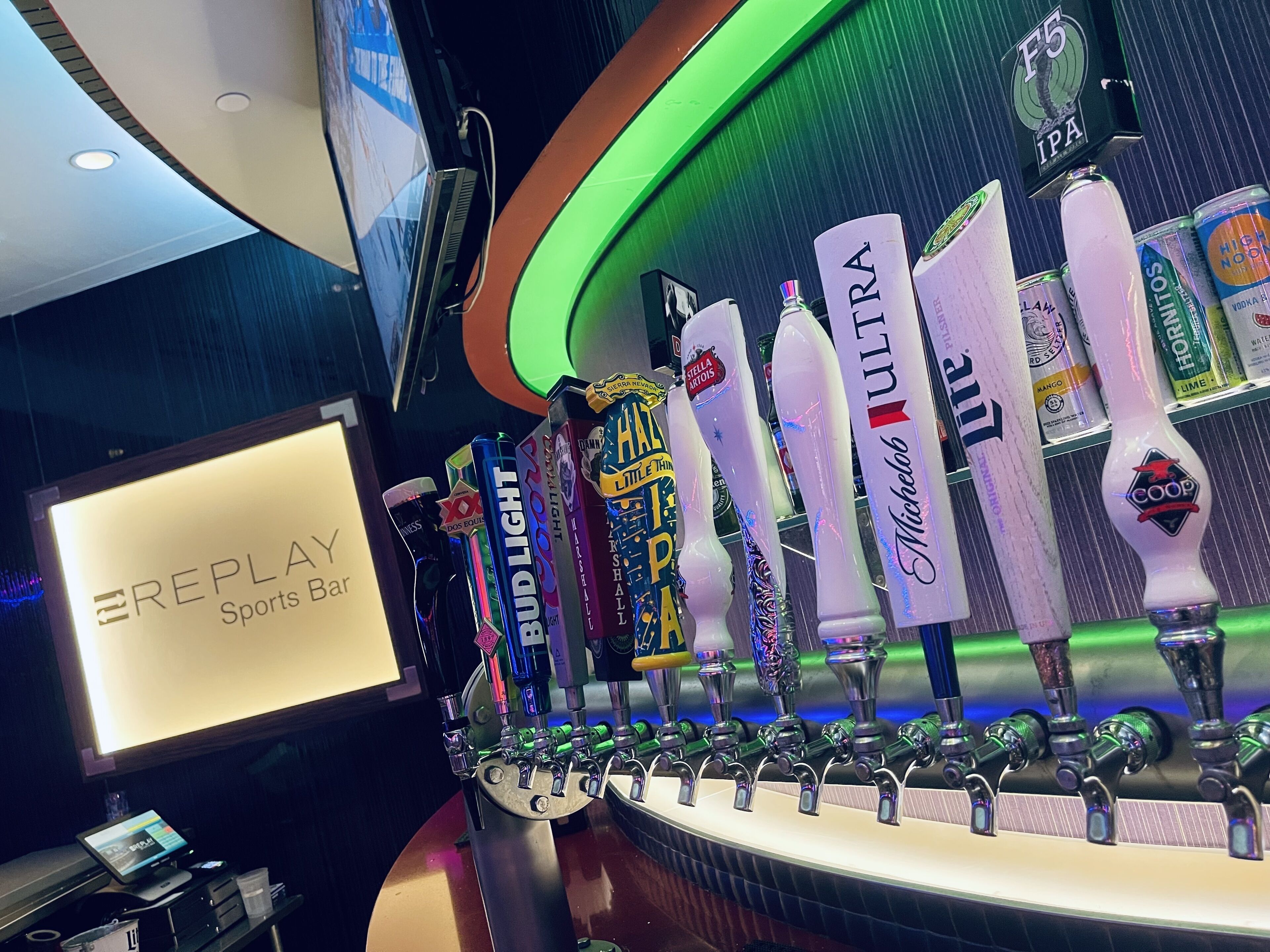 A bar area with multiple taps labeled with beer brands like Bud Light, Stella Artois, and Michelob Ultra.