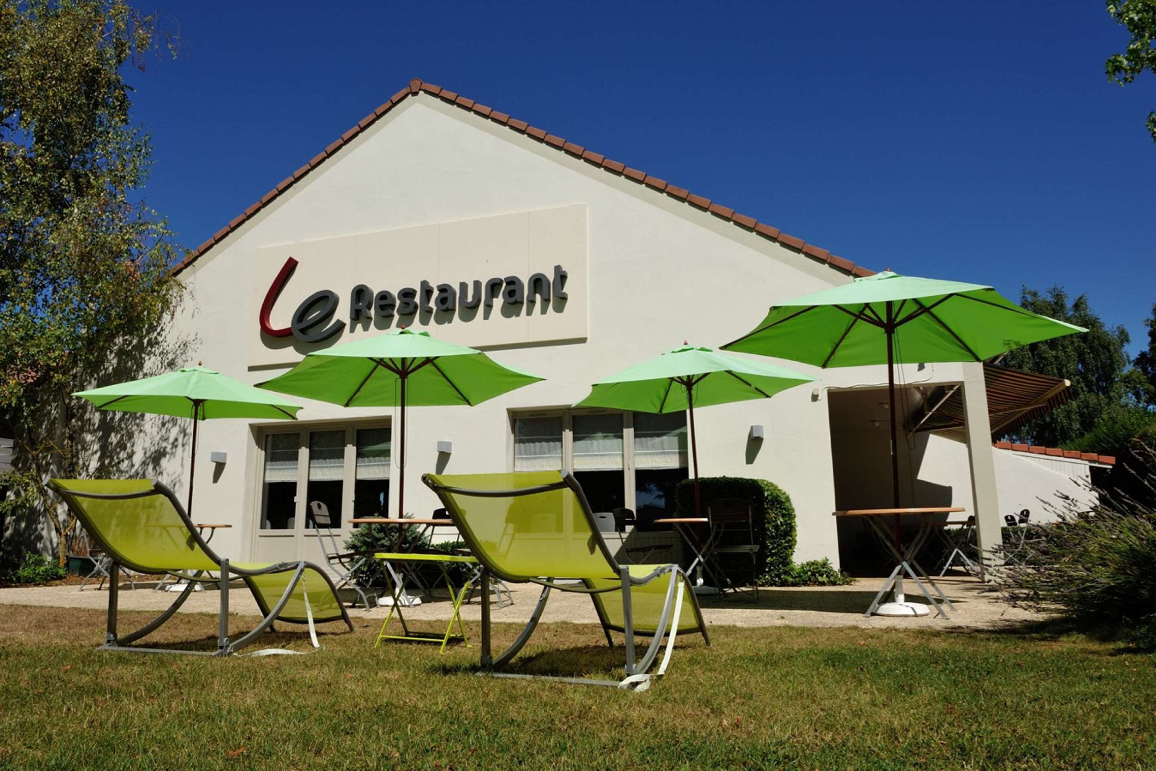 A restaurant with outdoor seating and umbrellas.