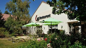 Een restaurant met terras en groene parasols.